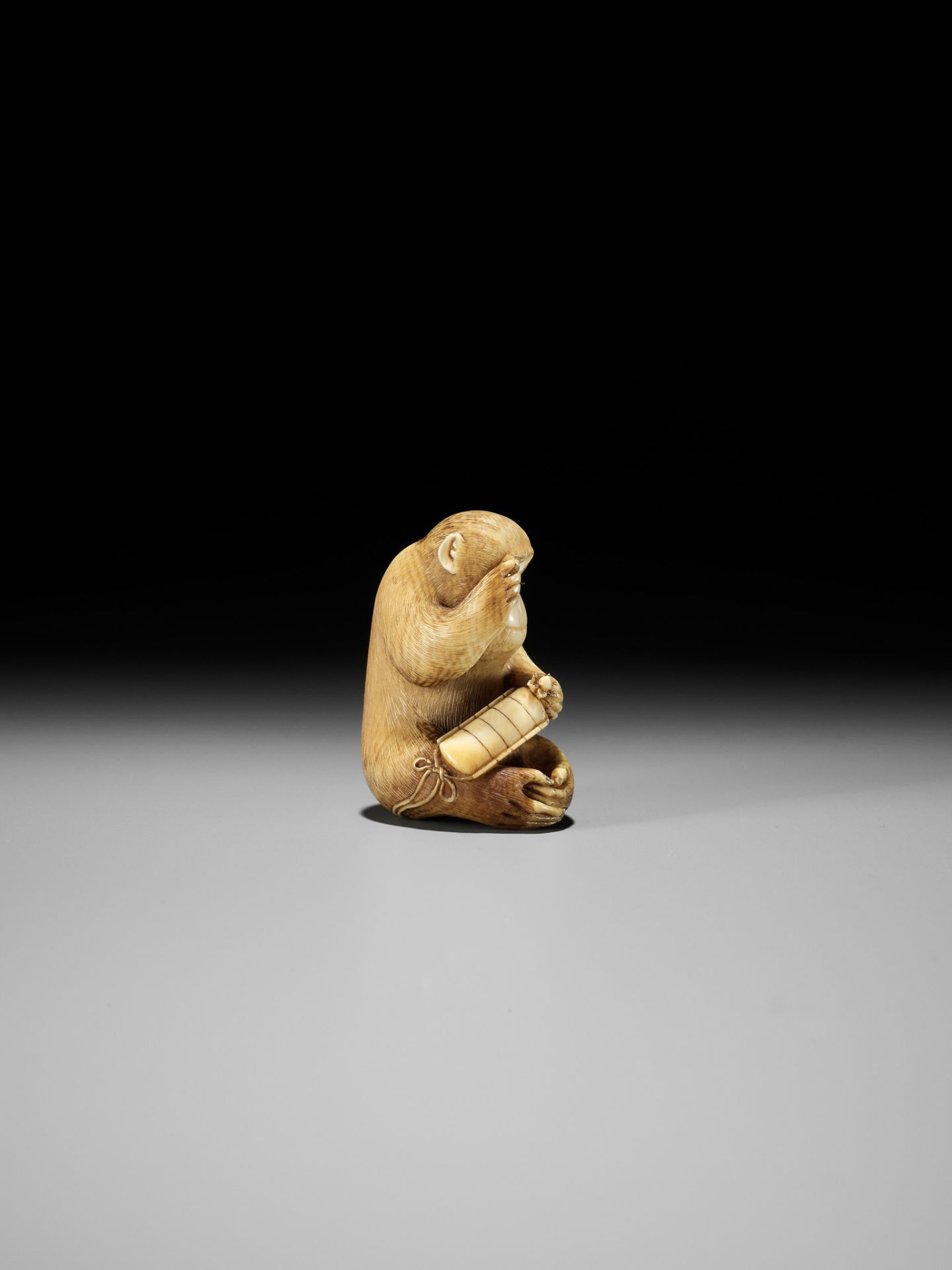 MASATOMO: AN AMUSING IVORY NETSUKE OF A SEATED MONKEY STUDYING A PEACH NETSUKE - Bild 2 aus 15