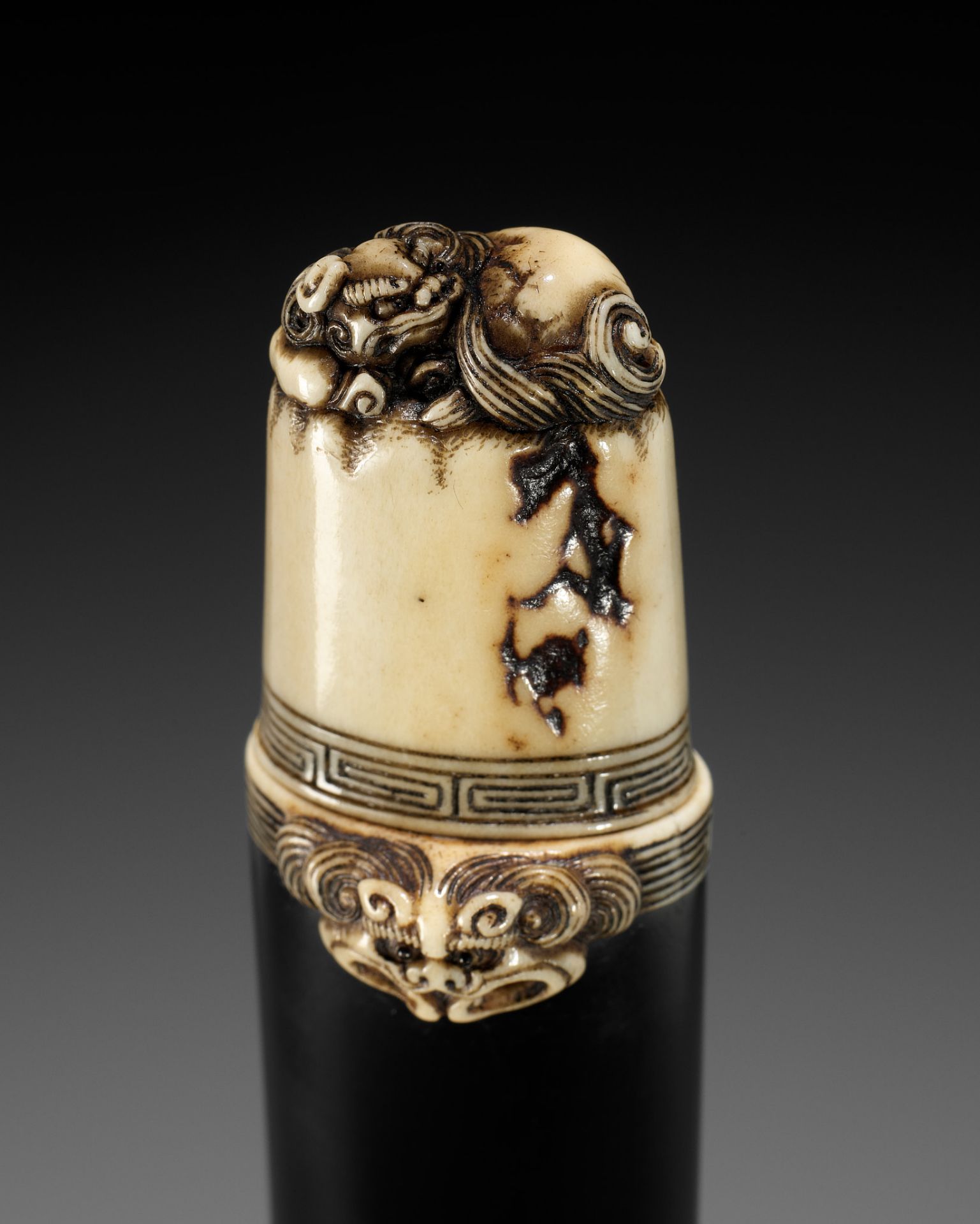 A FINE EBONY AND ANTLER KISERUZUTSU WITH SHISHI, ATTRIBUTED TO RENSAI