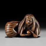 HOSAI: A FINE WOOD NETSUKE OF A NINGYO (MERMAID) CLUTCHING A PEARL