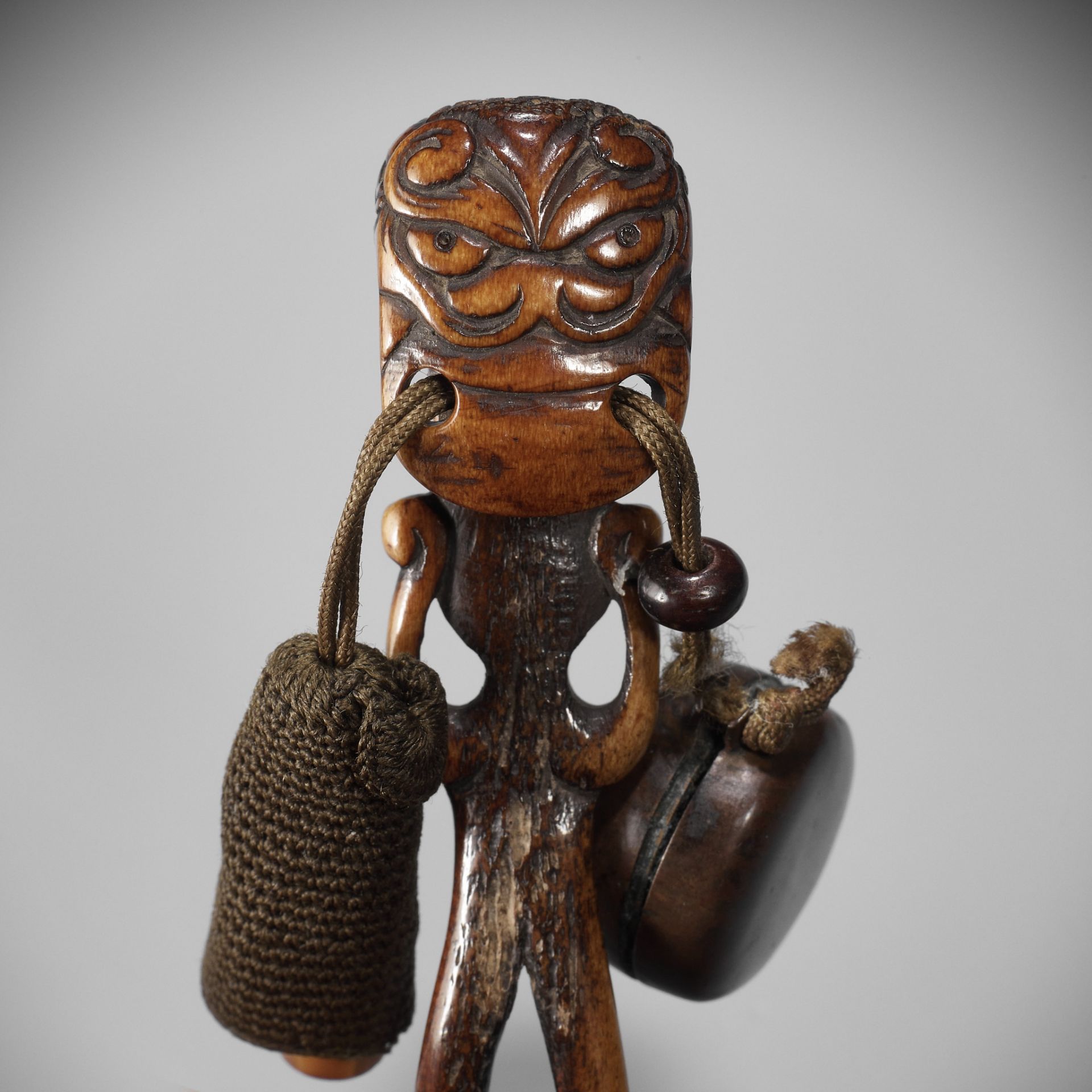 OZAKI KOKUSAI: A SUPERB ANTLER OBI-HASAMI NETSUKE DEPICTING A SHISHI-HEADED MONSTER