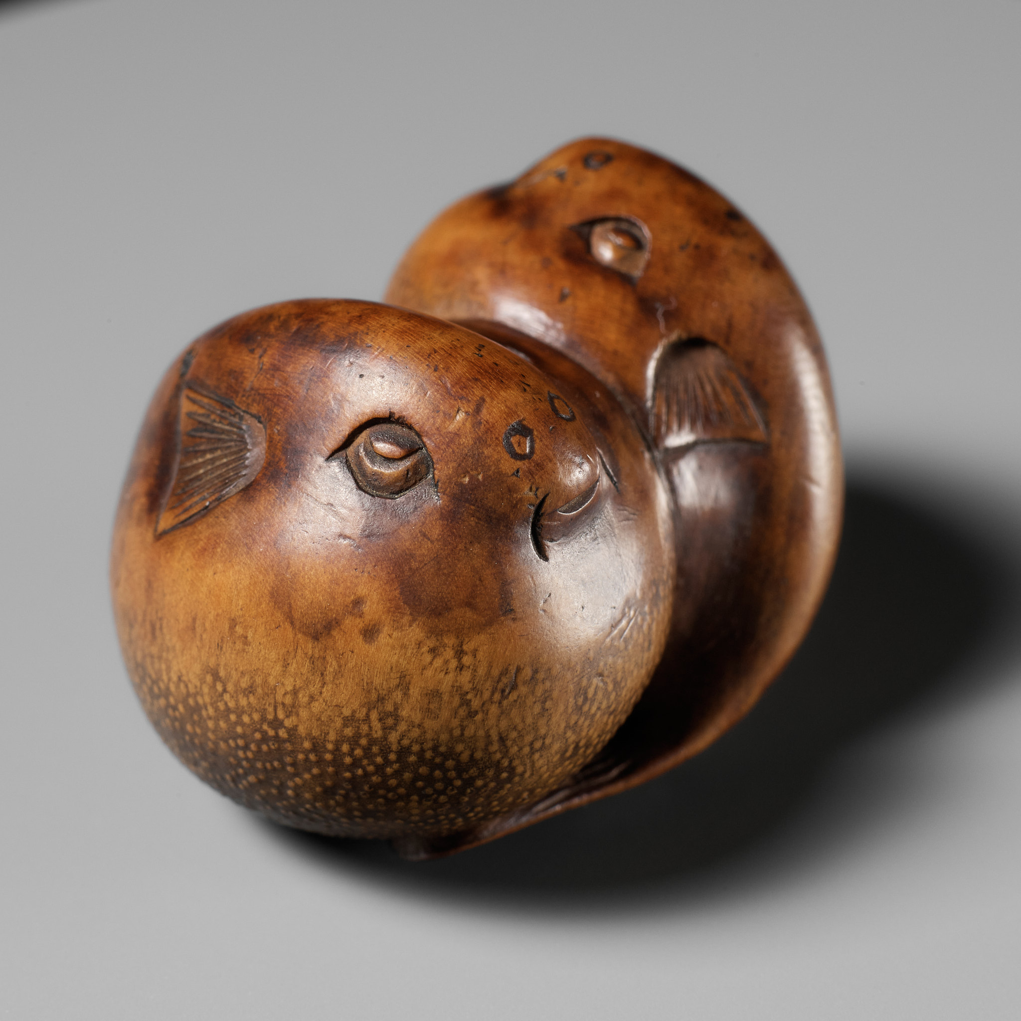 SARI: A SUPERB WOOD NETSUKE OF A PAIR OF BLOWFISH (FUGU)