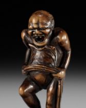 TOUN: AN AMUSING WOOD NETSUKE OF A NAKED MAN TYING HIS FUNDOSHI