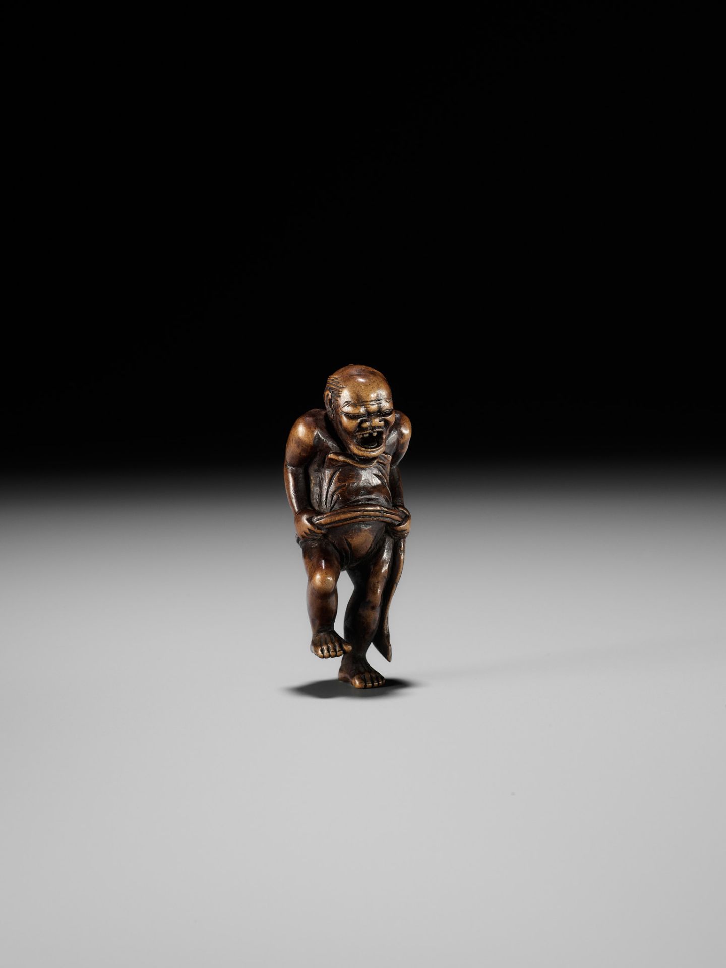 TOUN: AN AMUSING WOOD NETSUKE OF A NAKED MAN TYING HIS FUNDOSHI - Bild 8 aus 11