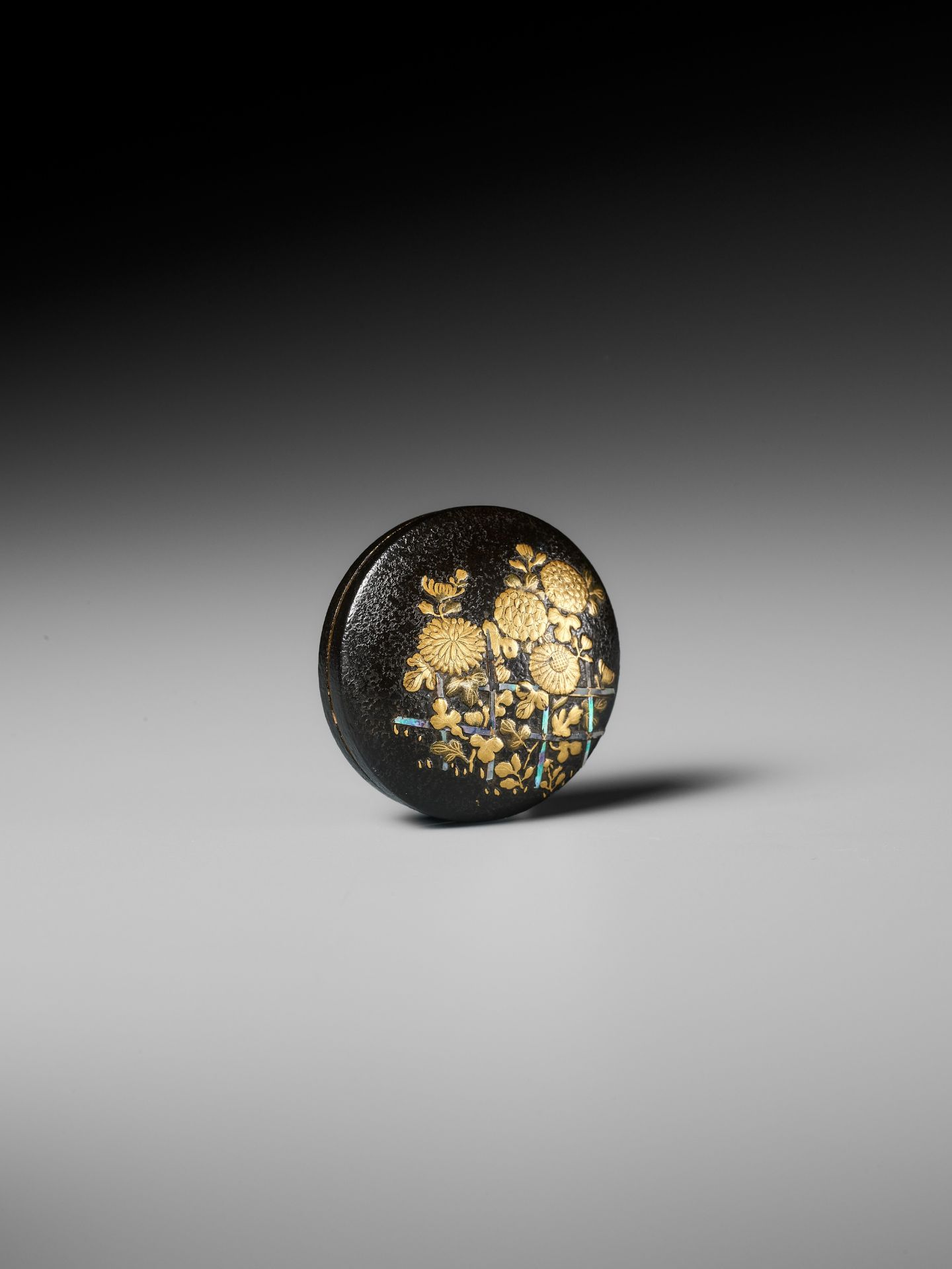 A LACQUERED WOOD MANJU NETSUKE DEPICTING CHRYSANTHEMUMS BY A FENCE - Image 4 of 8