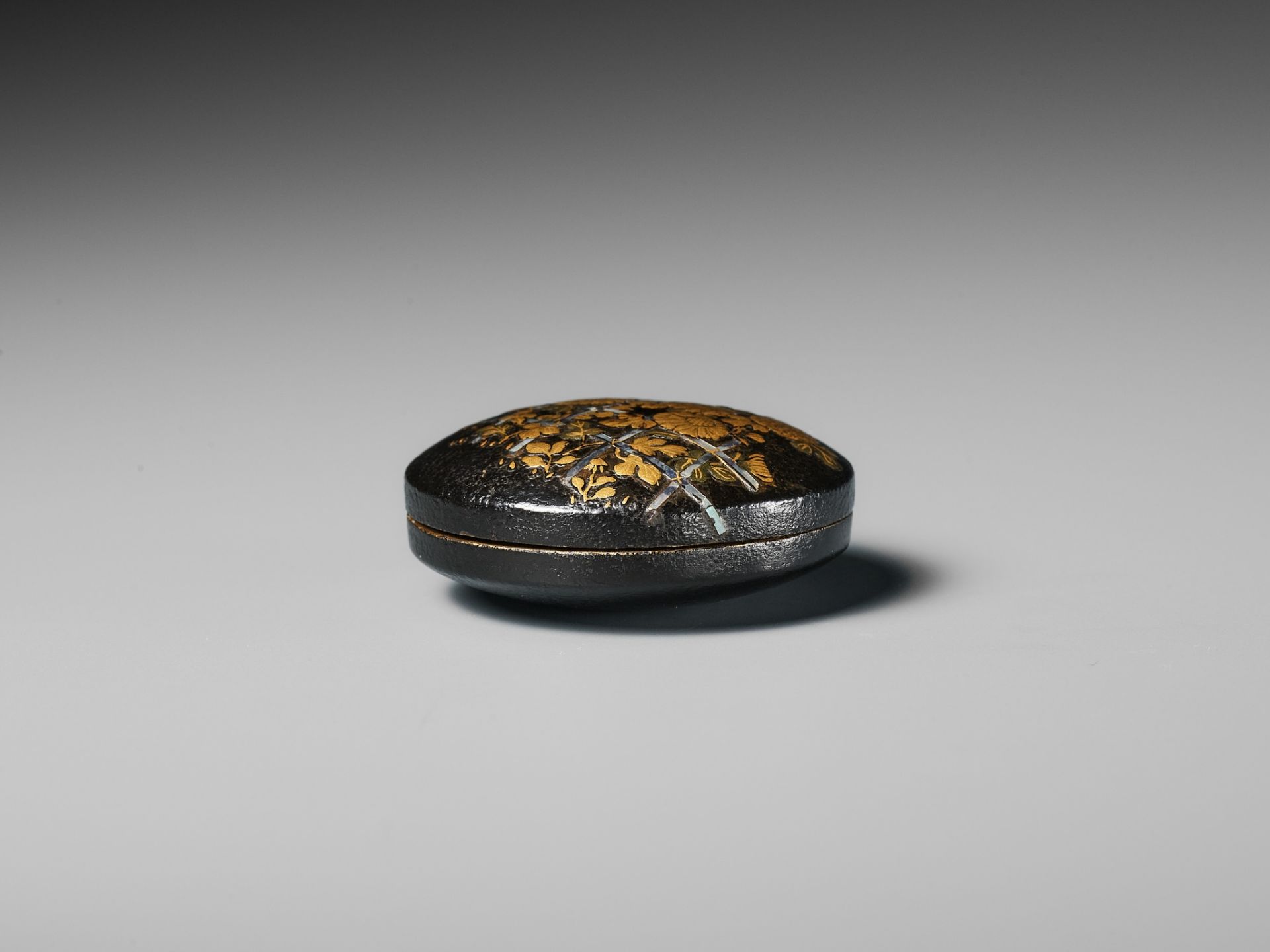 A LACQUERED WOOD MANJU NETSUKE DEPICTING CHRYSANTHEMUMS BY A FENCE - Image 6 of 8