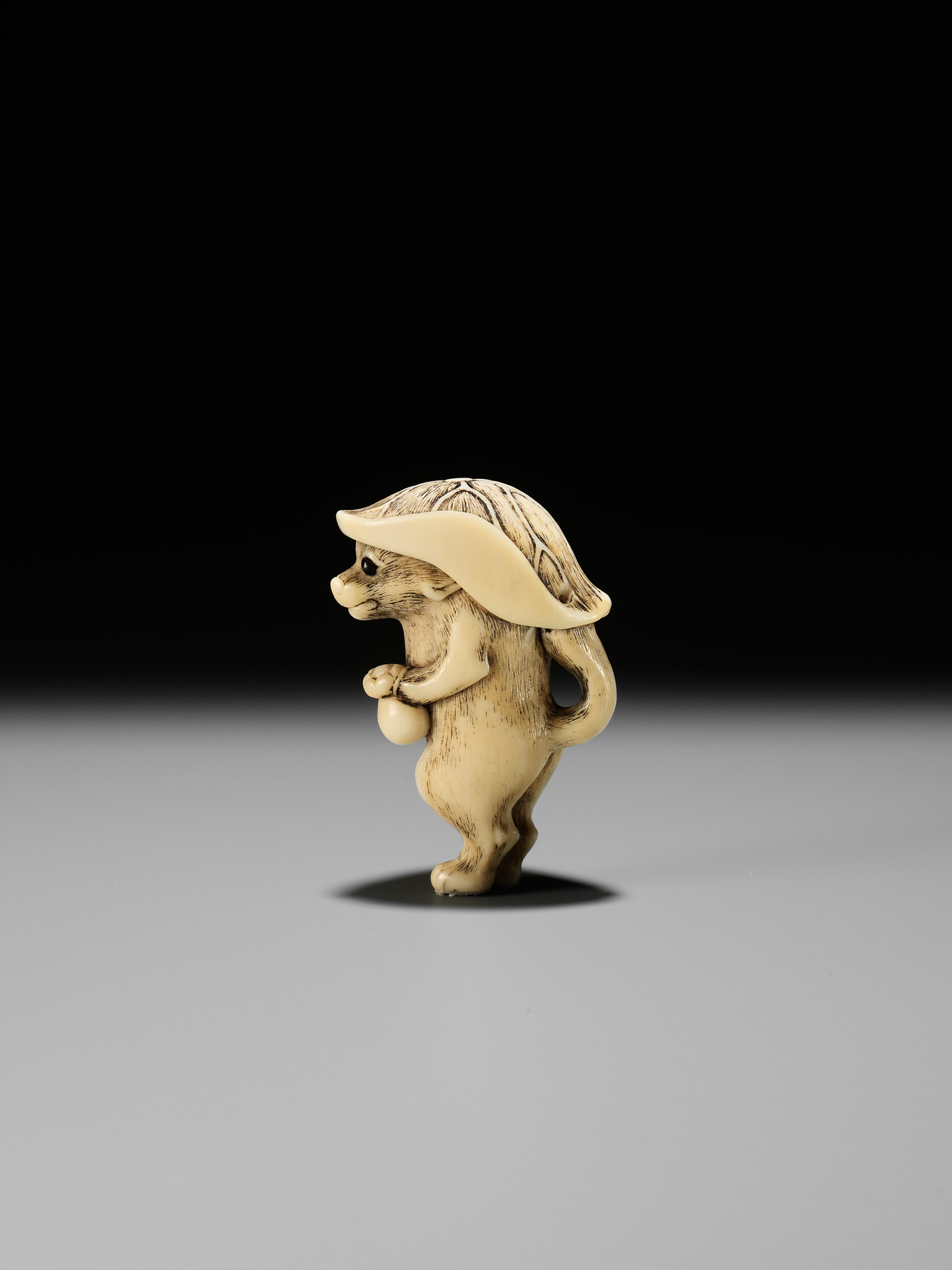 A HUMOROUS OSAKA SCHOOL IVORY NETSUKE OF TANUKI DISGUISED AS A SAKE VENDOR - Bild 2 aus 11