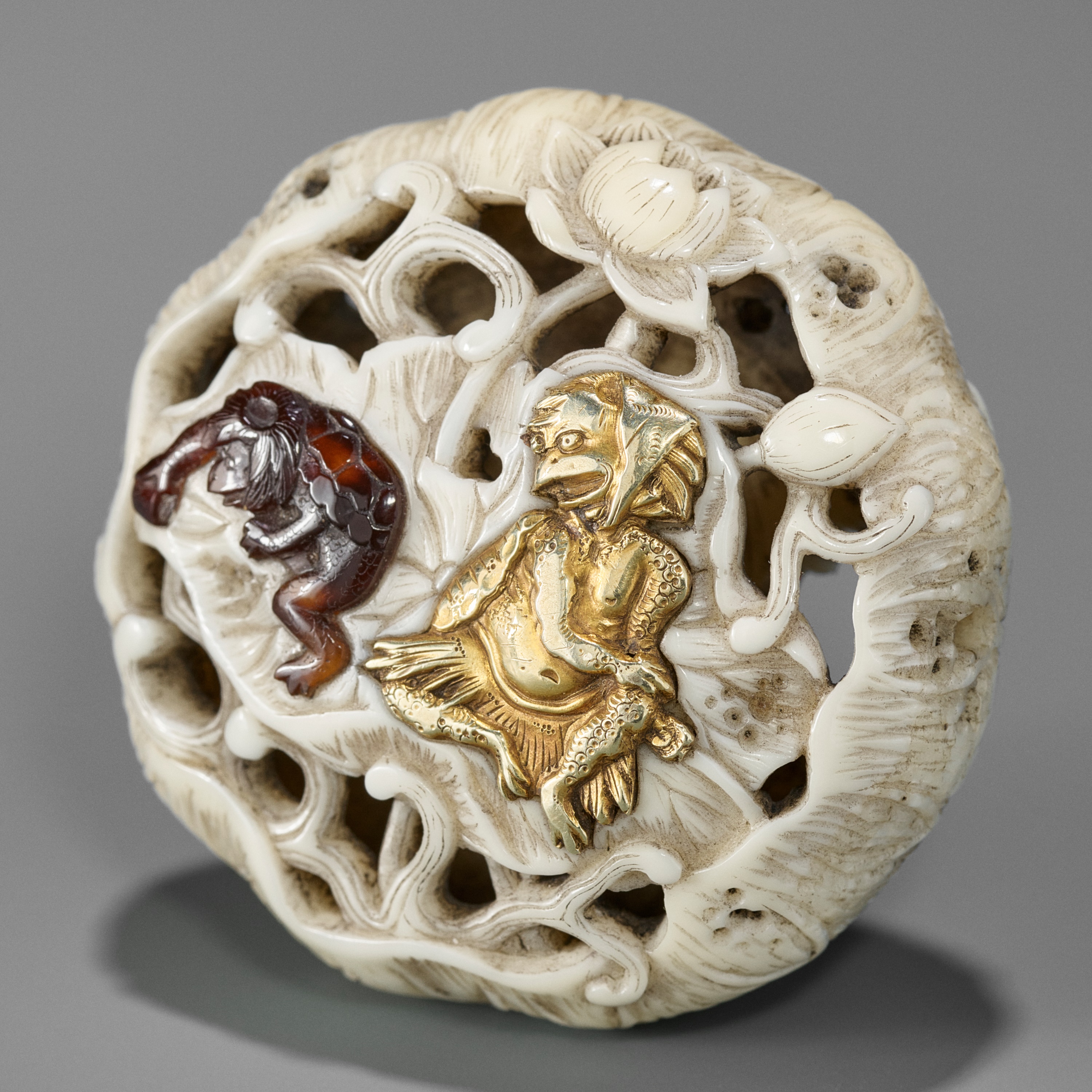 FUKU: A SUPERB GOLD-INLAID RYUSA MANJU NETSUKE DEPICTING KAPPA AND LOTUS