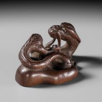 RAKUMIN: A FINE WOOD NETSUKE OF A DRAGON EMERGING FROM AN ASH POT