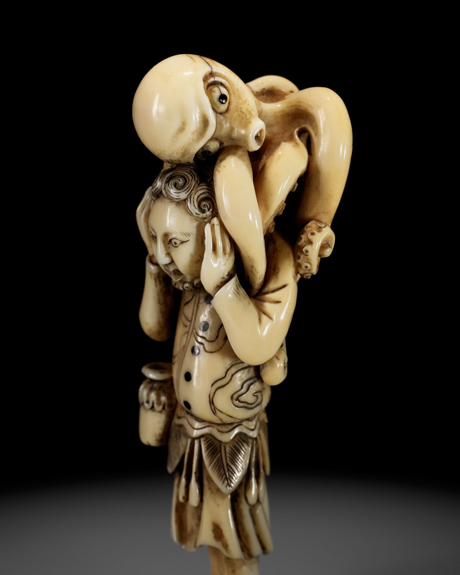 A RARE IVORY NETSUKE OF A DUTCHMAN WITH AN OCTOPUS