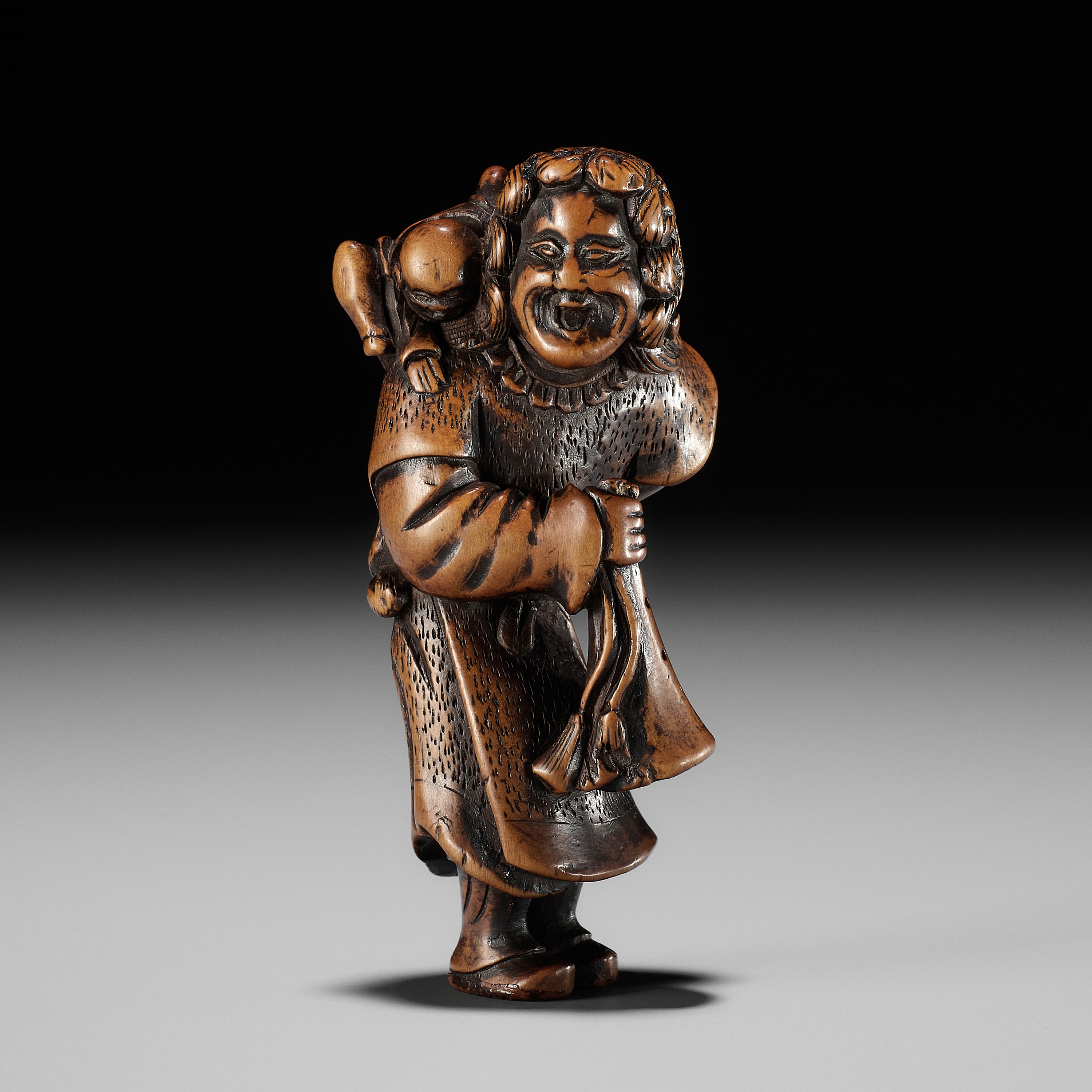 A GOOD WOOD NETSUKE OF A DUTCHMAN WITH CHILD