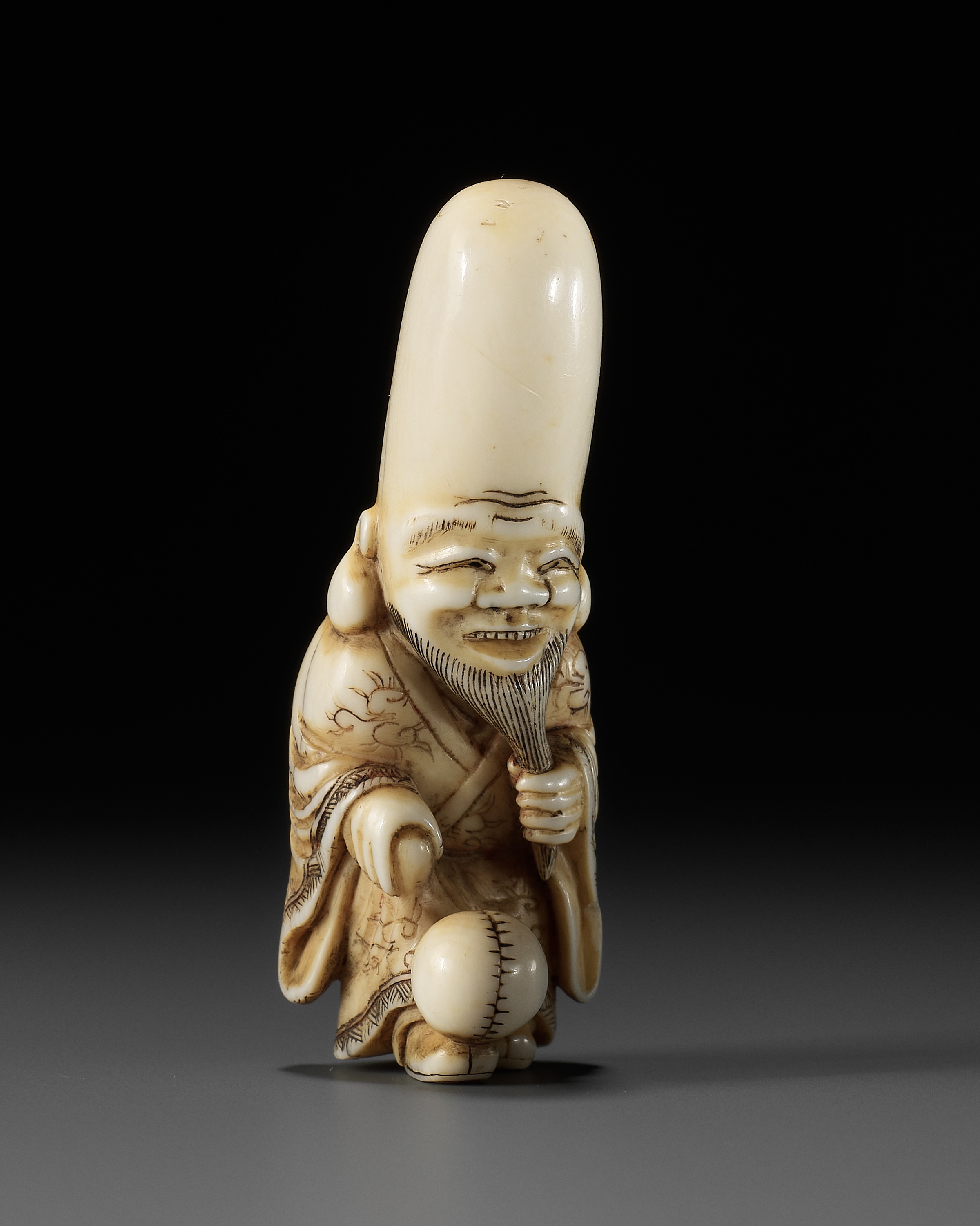 AN OSAKA SCHOOL IVORY NETSUKE OF FUKUROKUJU PLAYING KEMARI