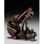 A FINE WOOD NETSUKE OF A WOLF AND SKELETON, ATTRIBUTED TO SHOKO SUGONOYA