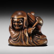 SENGYOKU: AN AMUSING WOOD NETSUKE OF DARUMA DISTURBED IN HIS MEDITATION