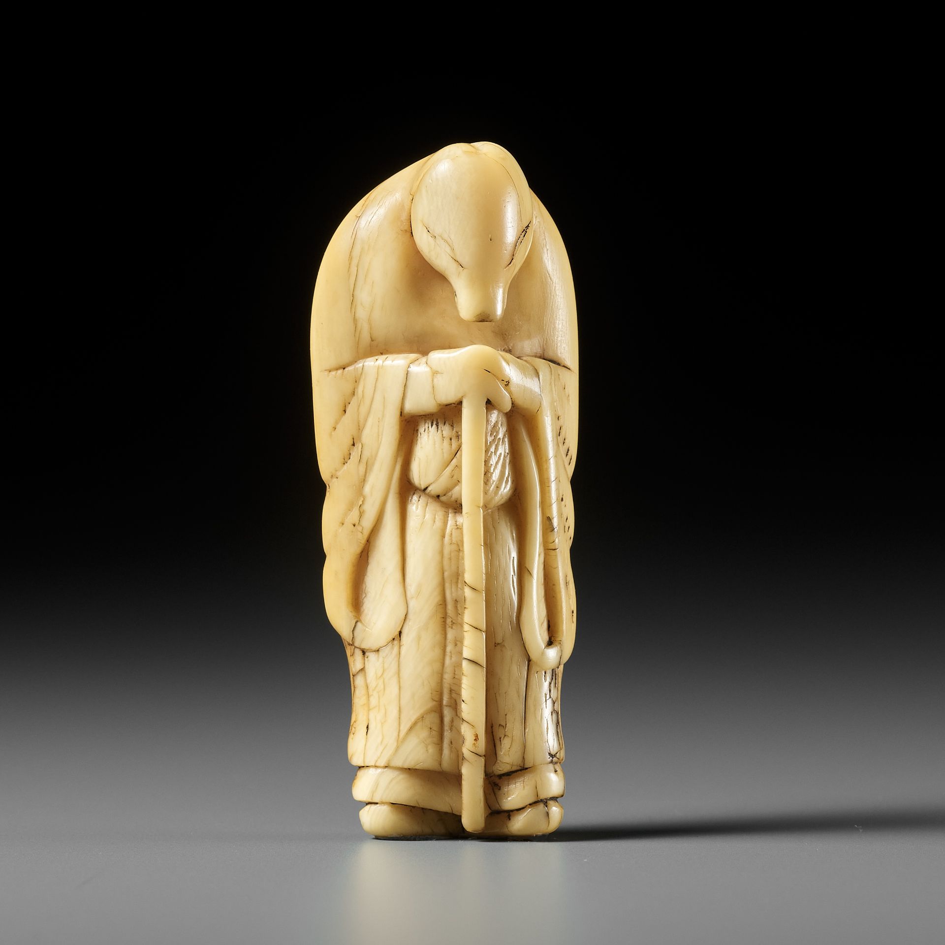 A FINE IVORY NETSUKE OF A FOX PRIEST (HAKUZOSU)