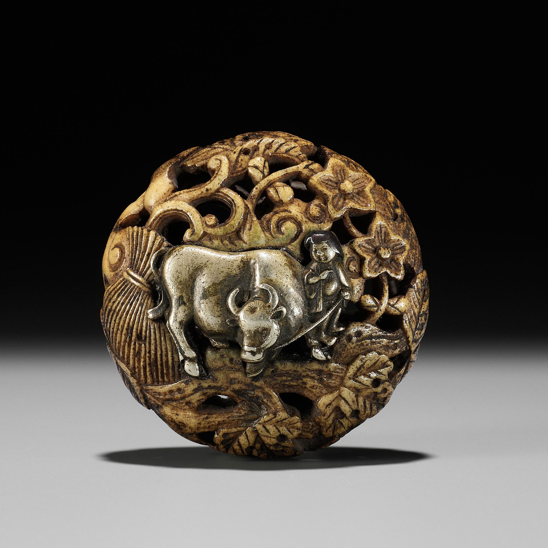 A METAL-INLAID ANTLER RYUSA MANJU NETSUKE REFERENCING THE TEN OX HERDING PICTURES