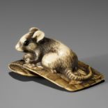 AN OSAKA SCHOOL IVORY NETSUKE OF A RAT ON A STRAW MAT