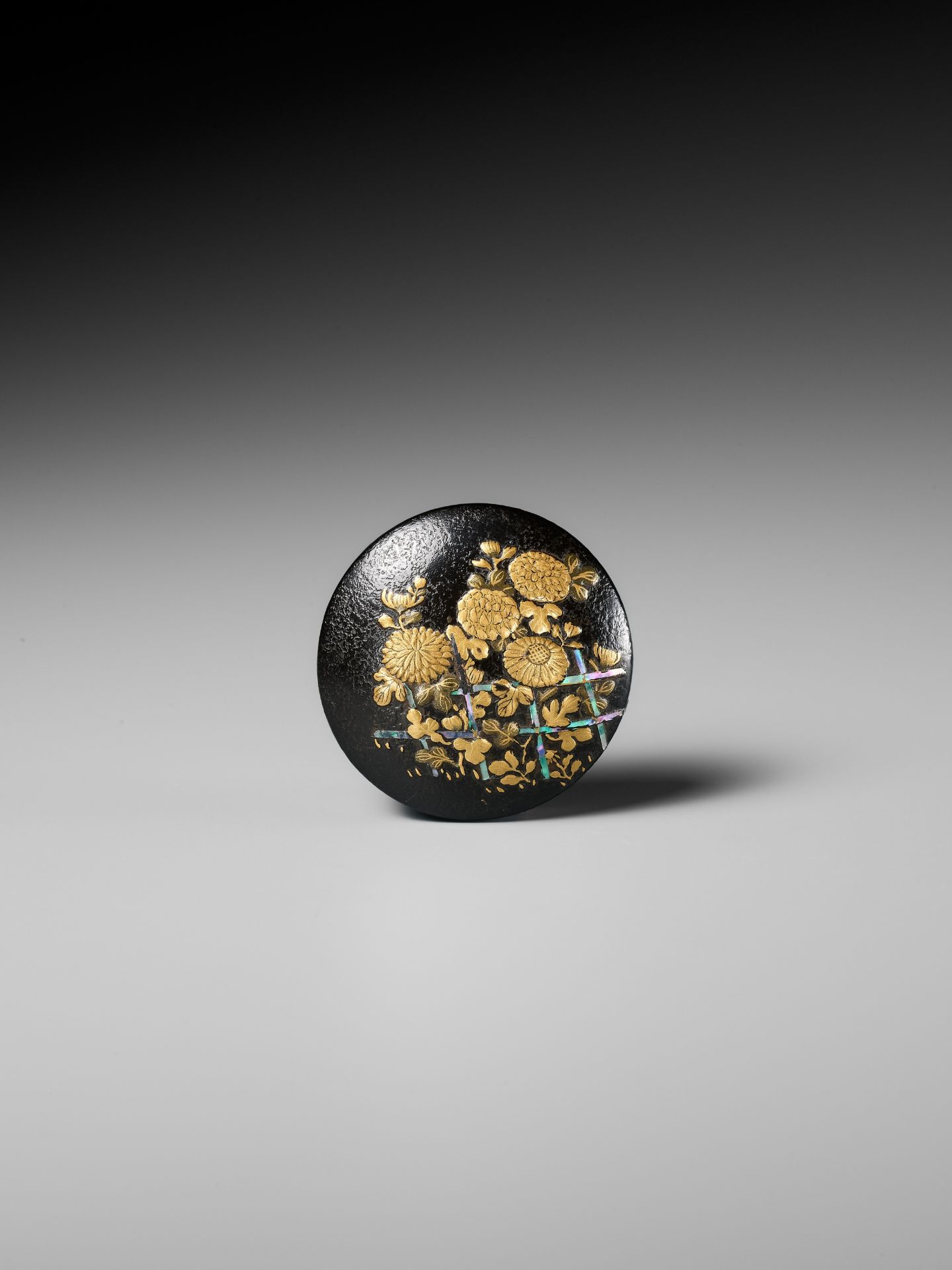 A LACQUERED WOOD MANJU NETSUKE DEPICTING CHRYSANTHEMUMS BY A FENCE - Image 2 of 8