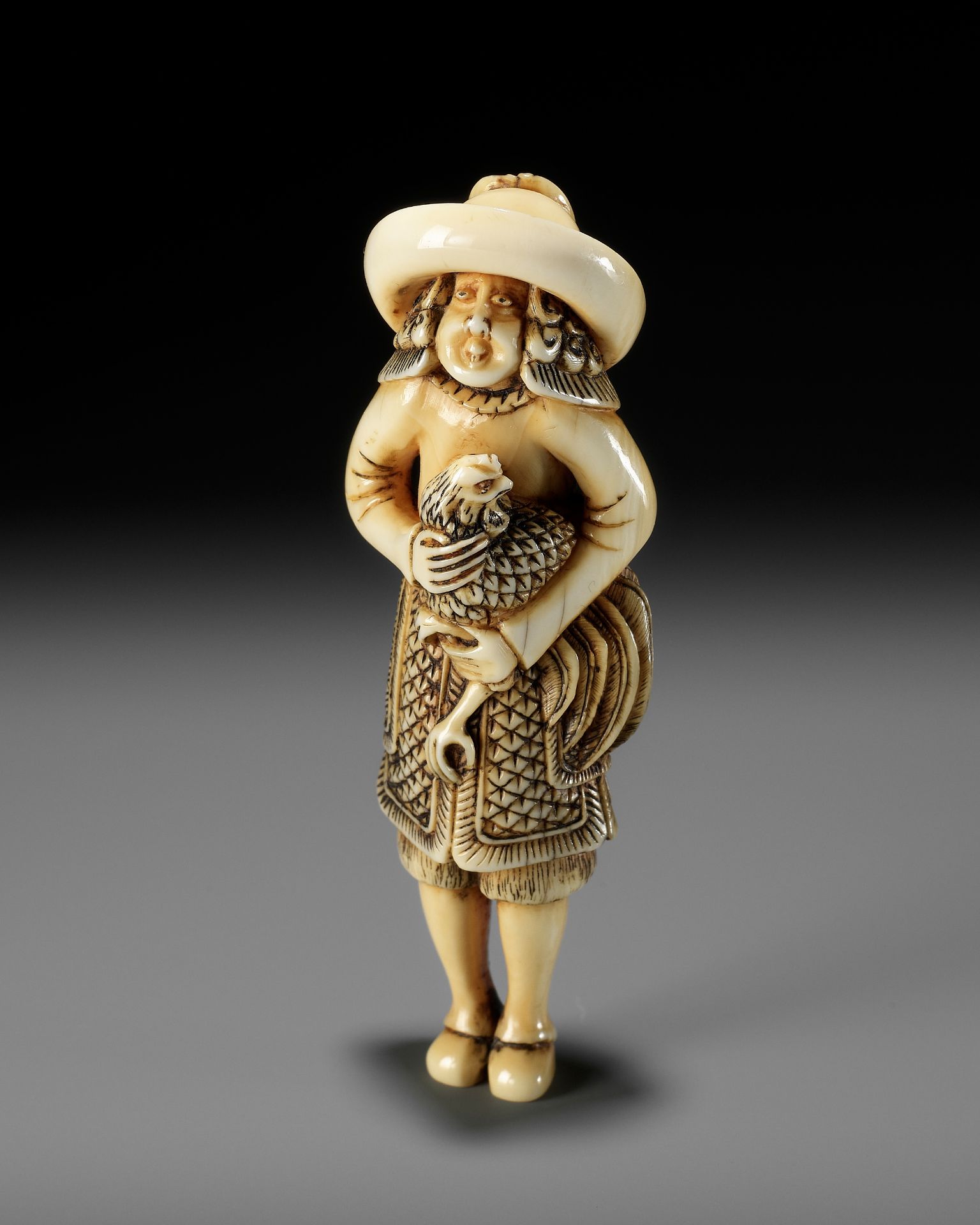 A FINE IVORY NETSUKE OF A DUTCHMAN WITH COCKEREL