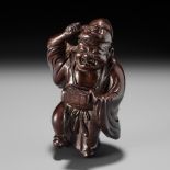 A FINE WOOD NETSUKE OF HOTEI AT SETSUBUN