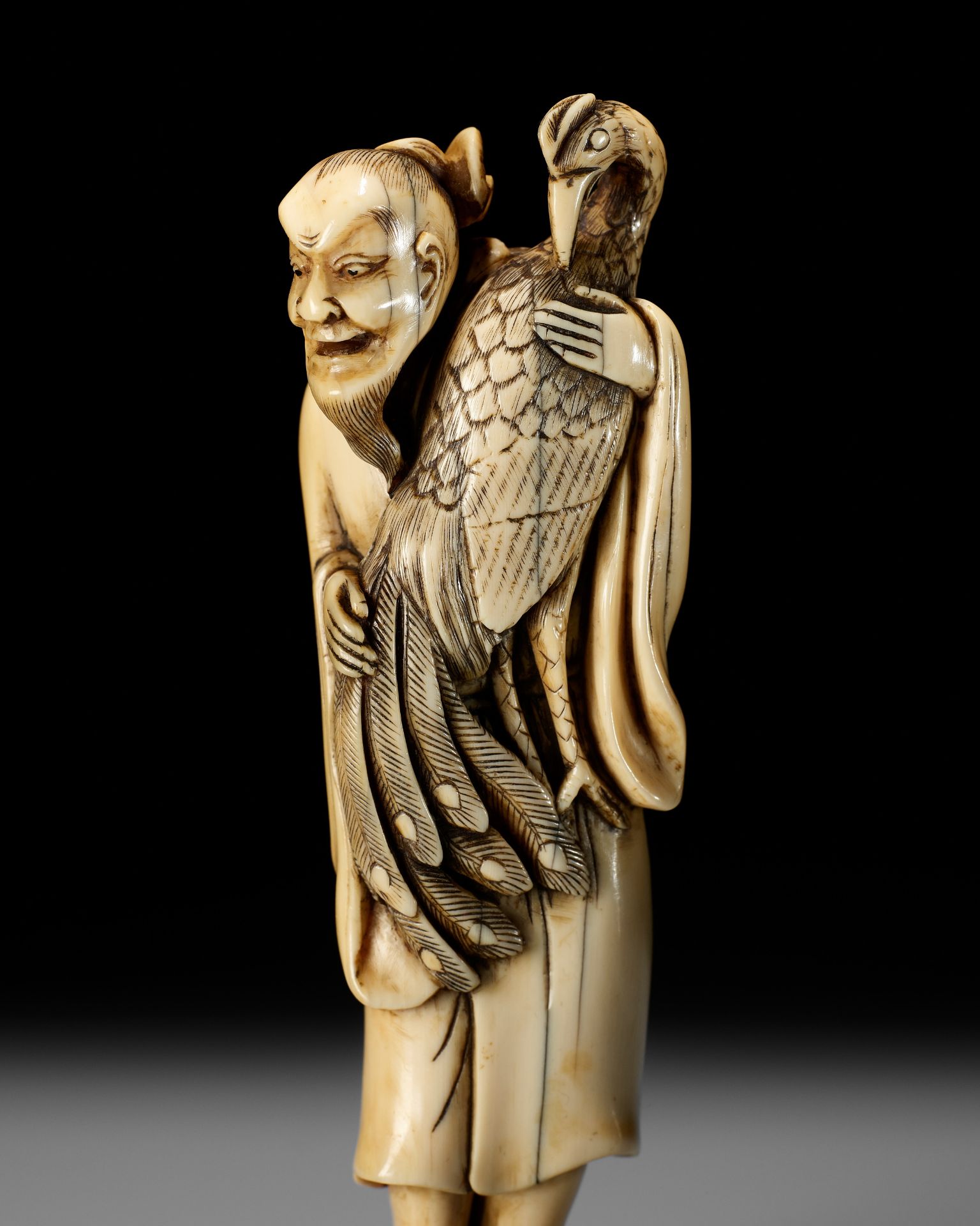 A VERY RARE AND LARGE IVORY NETSUKE OF BAIFUKU WITH HO-O BIRD