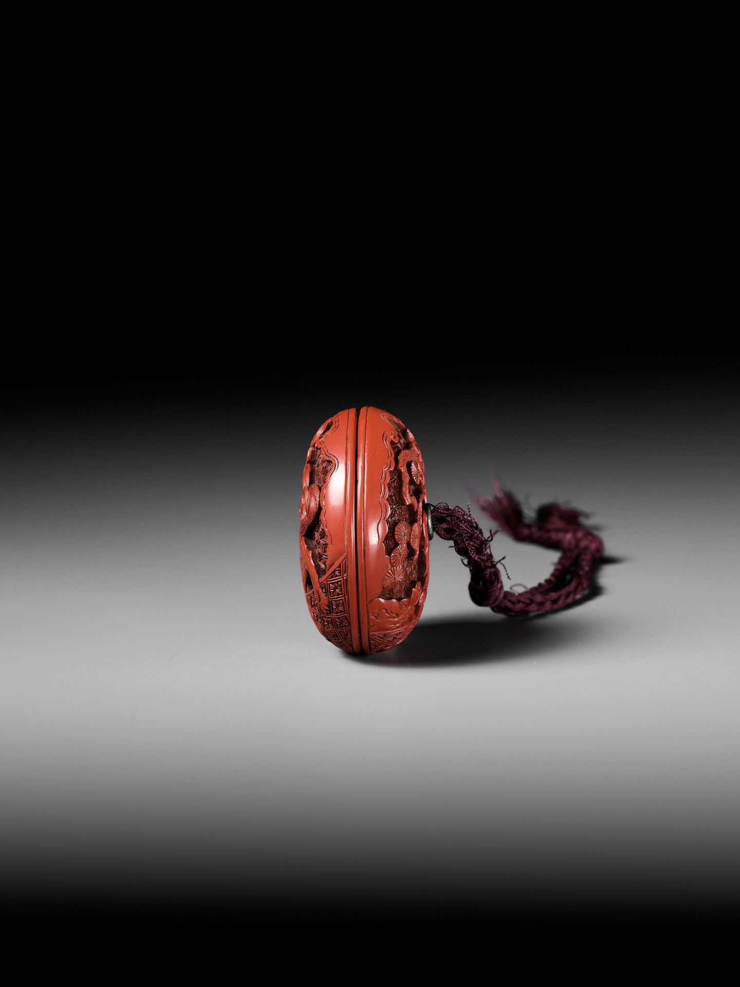 A FINE TSUISHU (CARVED RED LACQUER) MANJU NETSUKE WITH CHINESE LITERATI AND SHISHI - Image 8 of 9