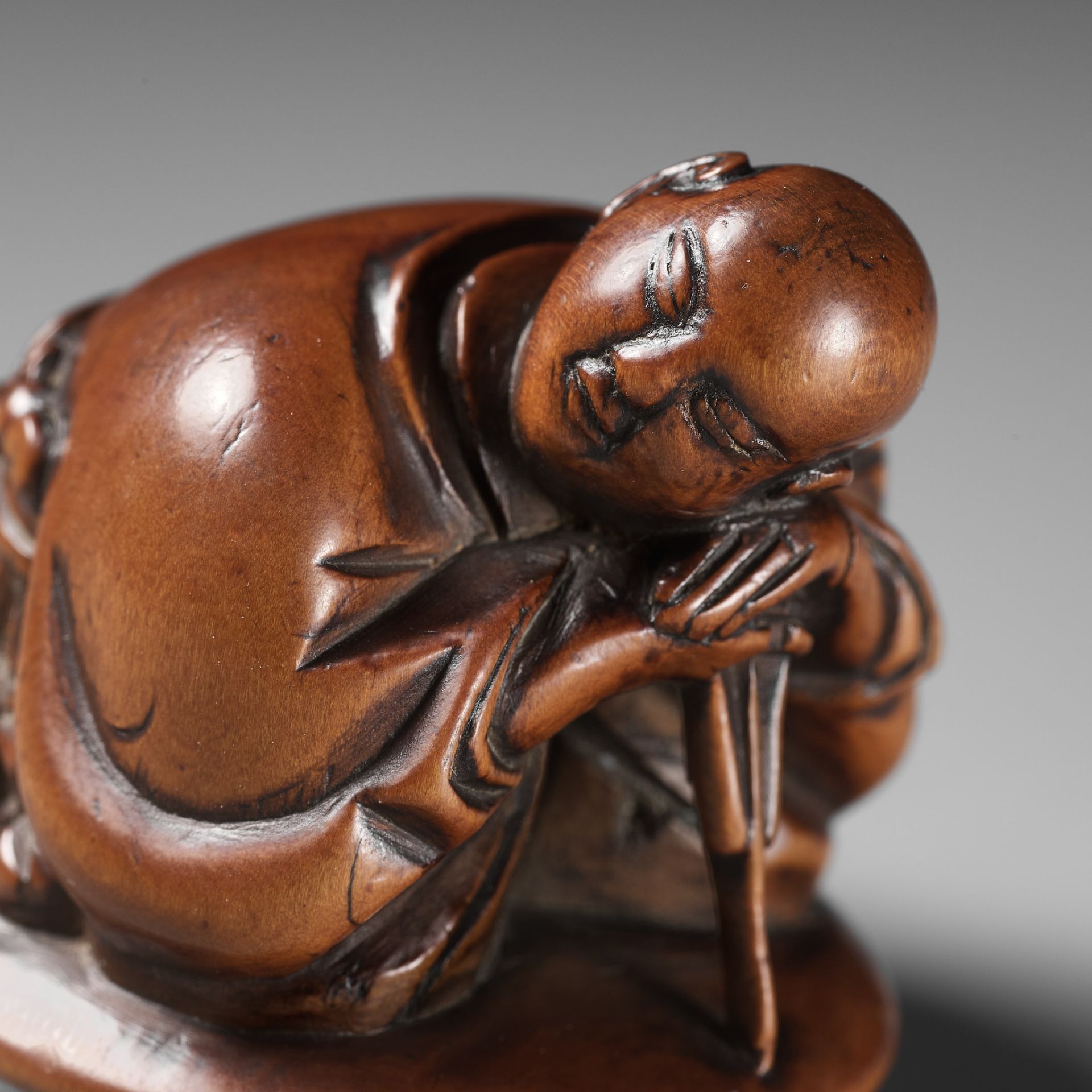 A REMARKABLE AND EARLY WOOD NETSUKE OF A SLEEPING ACTOR