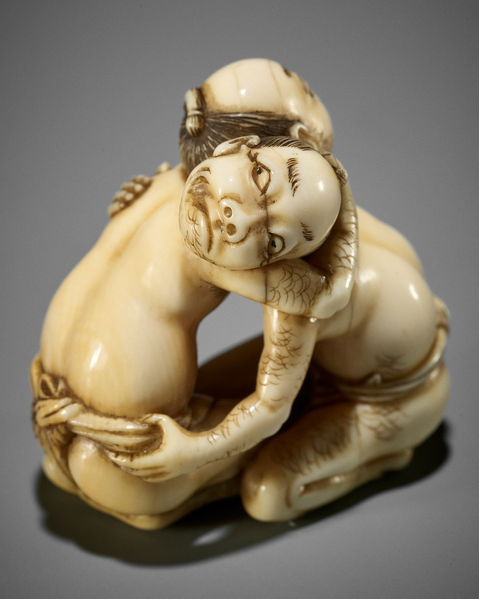 DORAKU: A SUPERB IVORY NETSUKE OF TWO WRESTLING DRUNKS