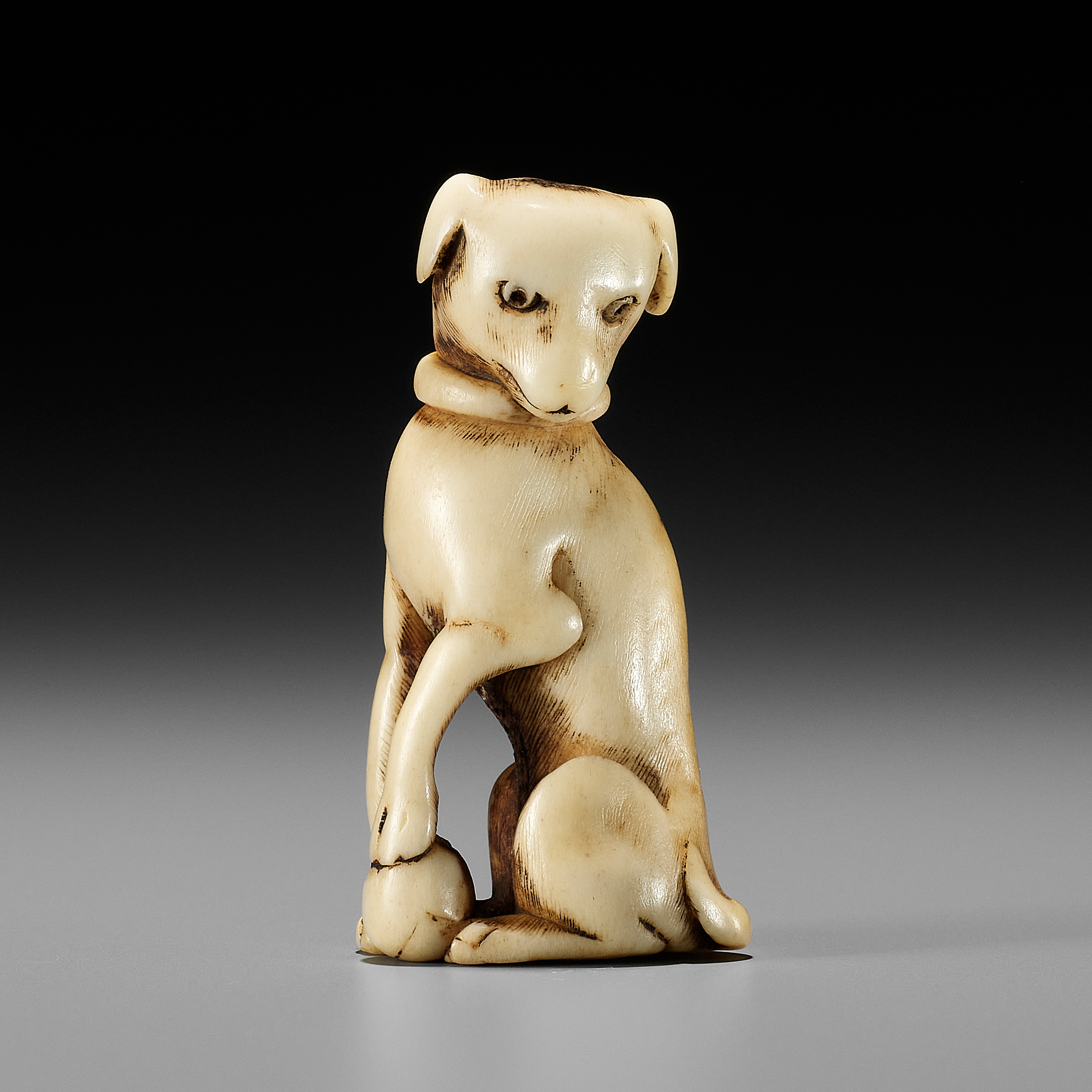 A KYOTO SCHOOL ANTLER NETSUKE OF A DOG