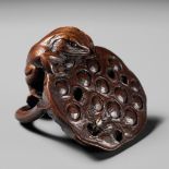 A RARE WOOD NETSUKE OF A FROG HUNTING A SPIDER ON A LOTUS POD