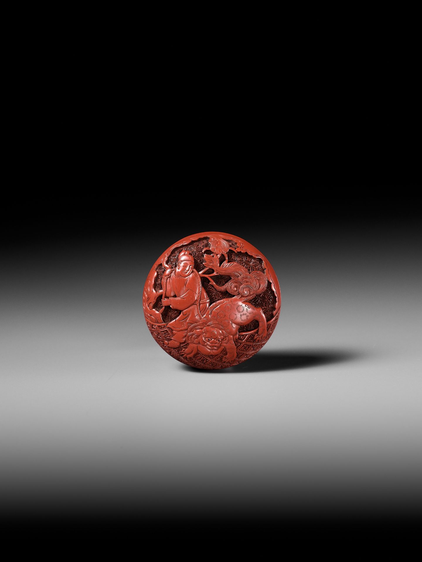 A FINE TSUISHU (CARVED RED LACQUER) MANJU NETSUKE WITH CHINESE LITERATI AND SHISHI - Image 6 of 9