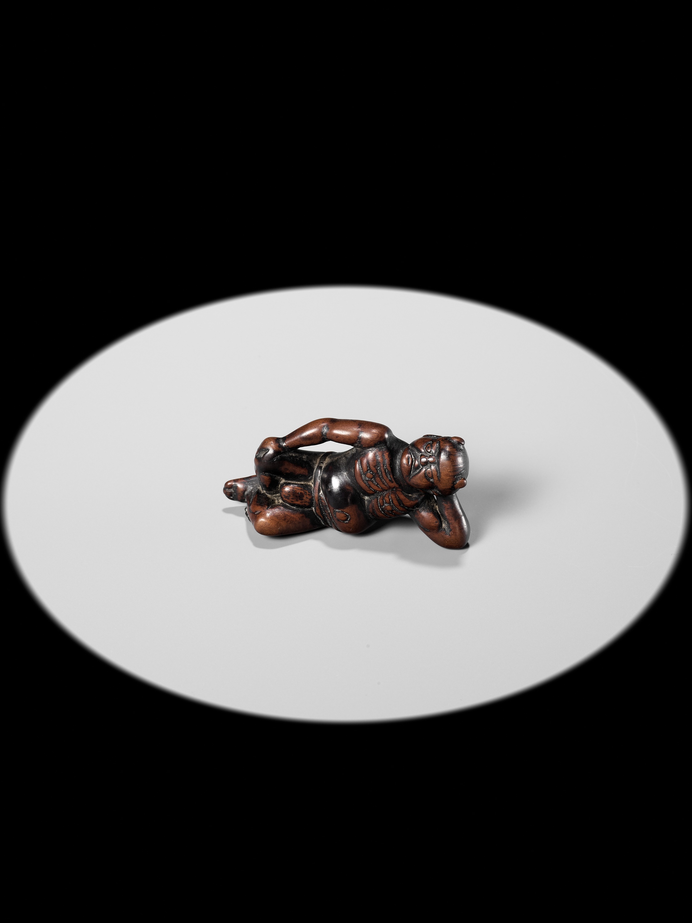 A RARE WOOD NETSUKE OF A RECLINING ONI - Image 3 of 10