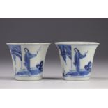 Pair of white and blue mugs decorated with characters from the late 19th century