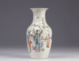A Famille Rose porcelain vase decorated with figures and a tree on a white background