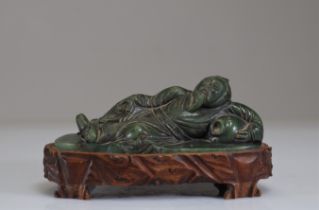 Carved spinach jade reclining figure from Qing period