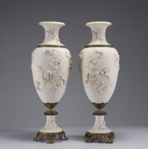 Imposing pair of white vases decorated with angels on a bronze base, 19th century.