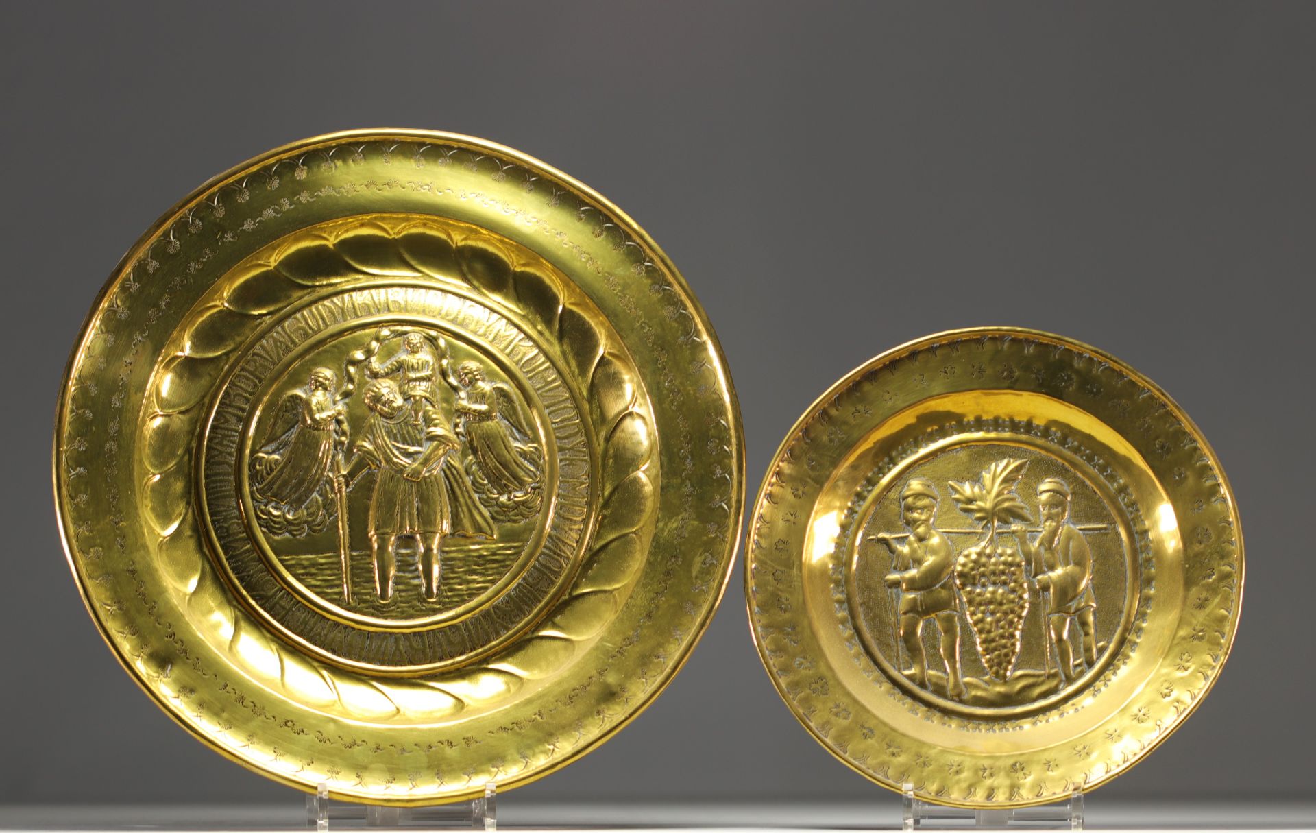 Set of two embossed and repousse brass offering dishes decorated with religious scenes.