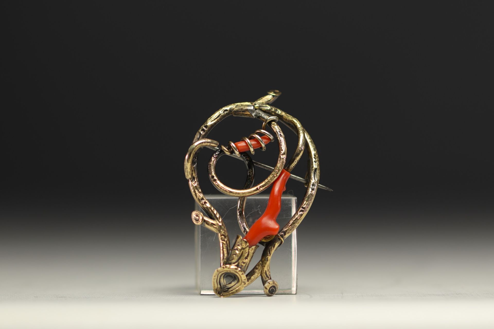 Brooch in various alloys of gold, silver and coral.