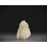 China - White jade pendant in the shape of a fruit surmounted by a young child.