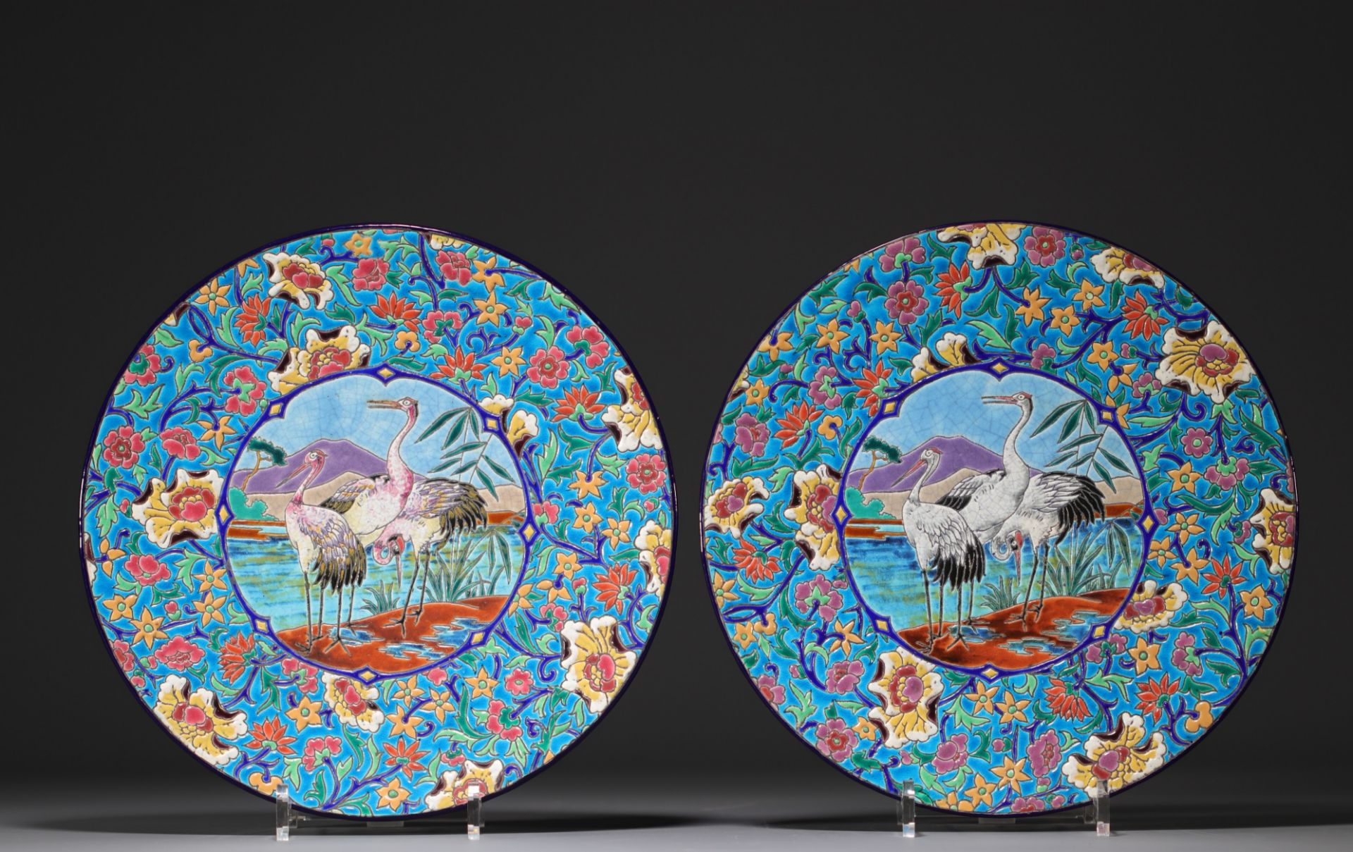 Longwy - Pair of large enameled plates decorated with cranes.