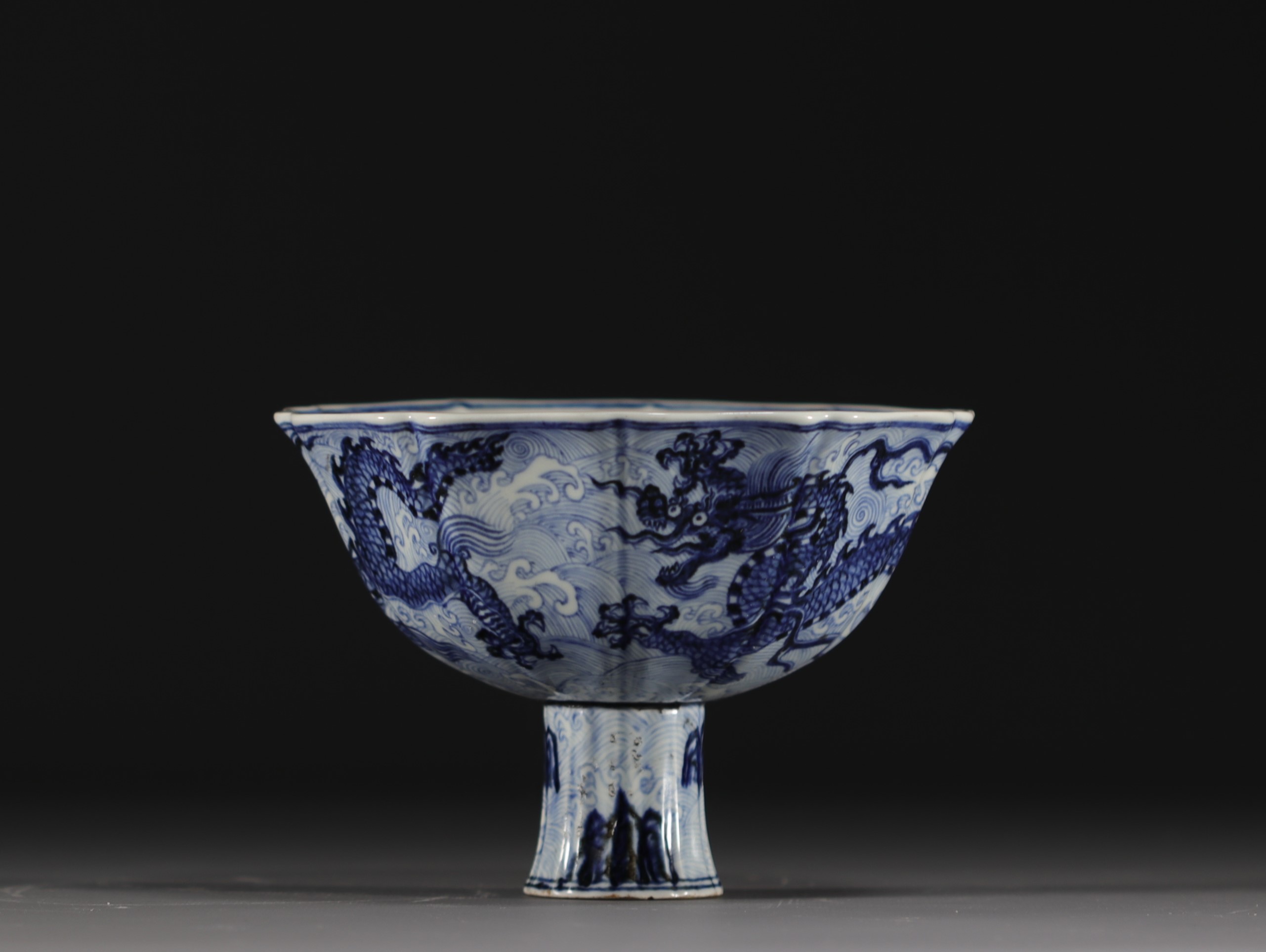 China - Bowl on foot in blue-white porcelain decorated with dragons in waves, Xuande mark.