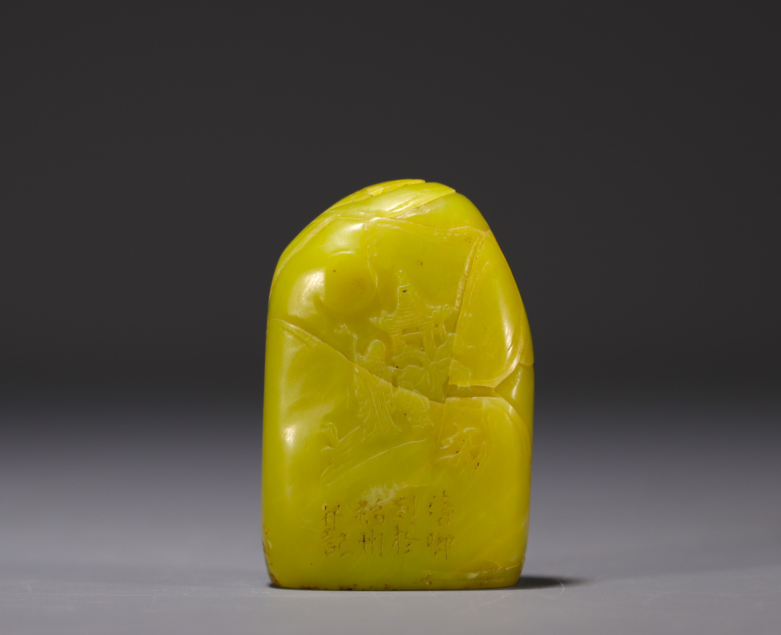 China - Yellow stone seal carved with a figure in a landscape and engraved with a poem.