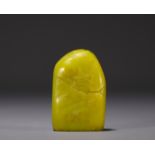 China - Yellow stone seal carved with a figure in a landscape and engraved with a poem.