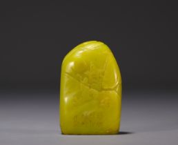 China - Yellow stone seal carved with a figure in a landscape and engraved with a poem.