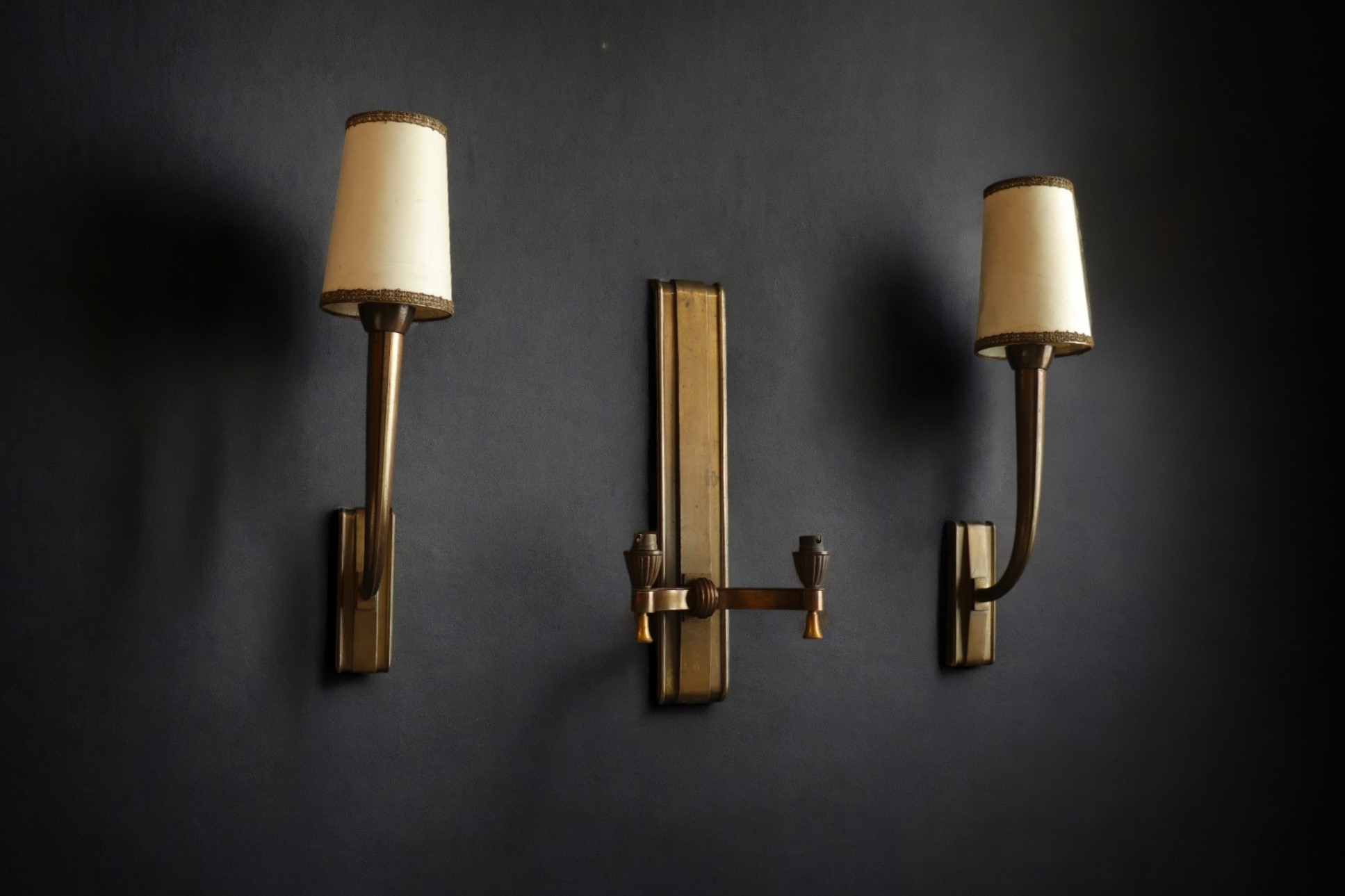 Jean PASCAUD (1903-1996) Set consisting of a double sconce and a pair of single sconces in patinated