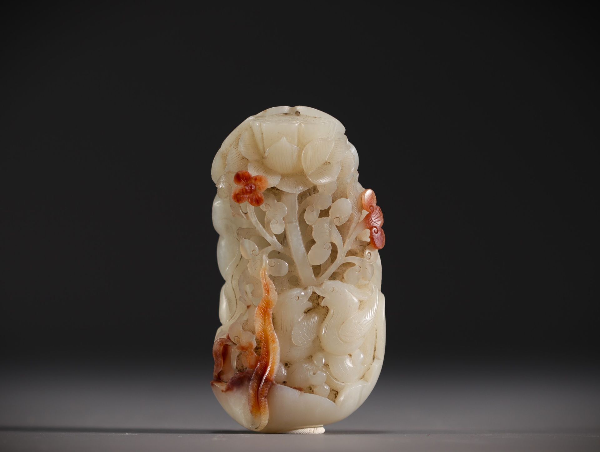 China - White and brown jade pendant with lotus flower and duck design.