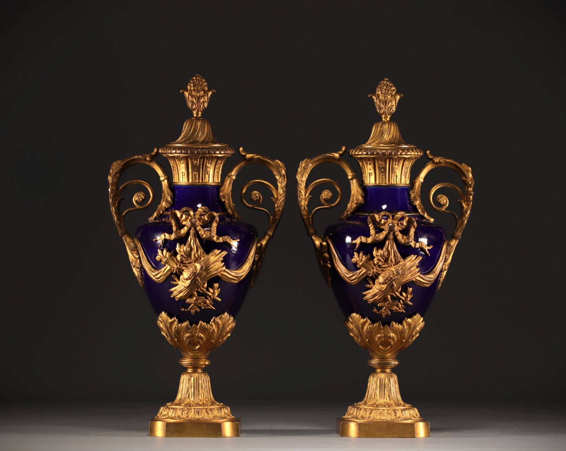 Pair of Louis XVI style covered vases in "bleu de Sevres" porcelain, gilded and chased bronzes.