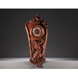 Art Nouveau clock in carved walnut with a half-dressed lady and floral decoration, enamel numerals, 