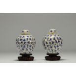 China - Pair of white-blue porcelain covered pots with children, wooden base.