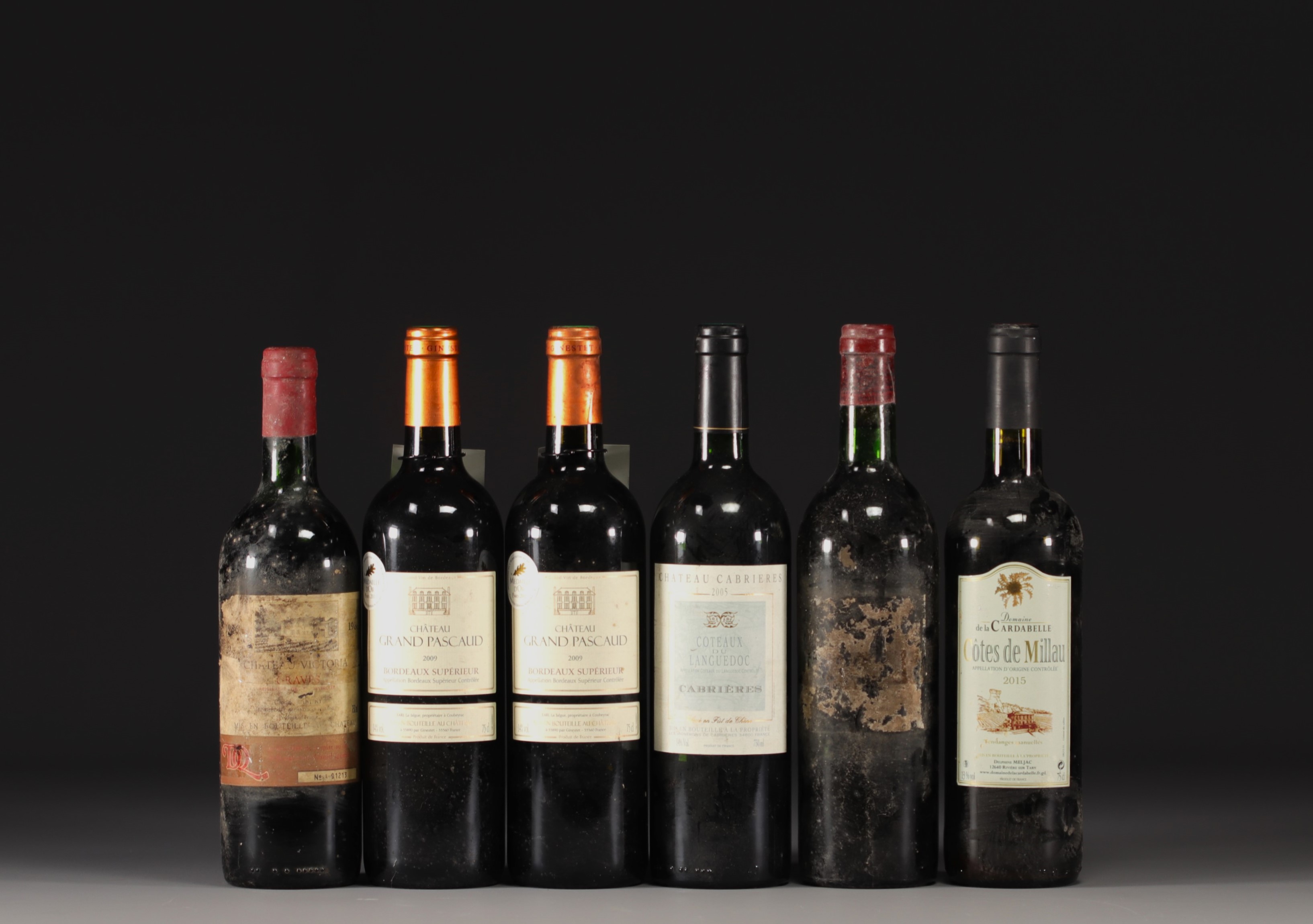 Set of 13 bottles of wine from various regions.