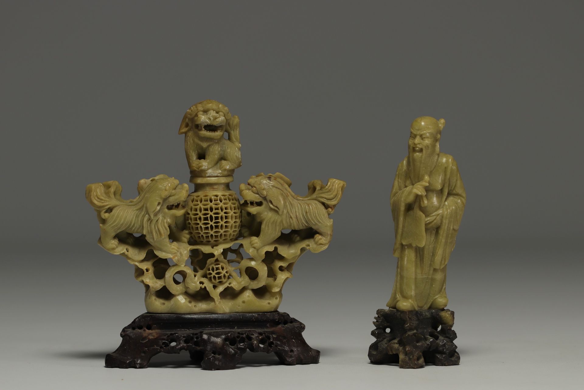 China - Set of two hard stone sculptures, one decorated with lions and a Sage, on wooden bases.